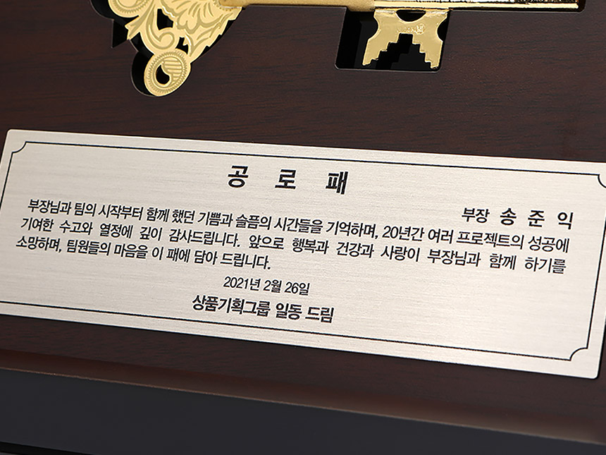 정교한 금속 결합 디테일이 돋보이는 순금 열쇠 상패 측면 클로즈업