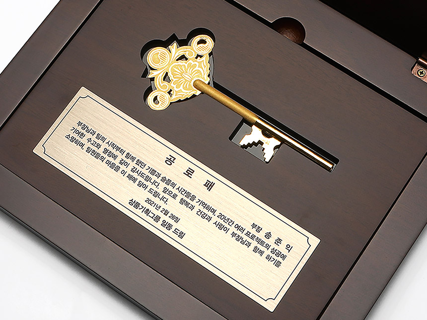 키 부분이 강조된 순금 열쇠 상패 클로즈업 이미지