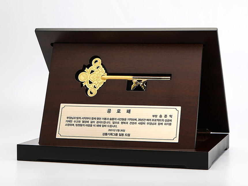 빛을 받아 반짝이는 정교한 디자인의 순금 열쇠 상패