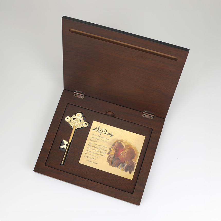 빛을 받아 반짝이는 정교한 디자인의 순금 열쇠 상패